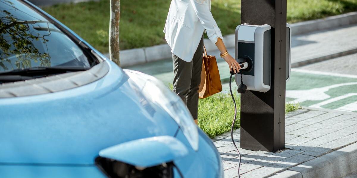 mobilité électrique femme chargeant son véhicule