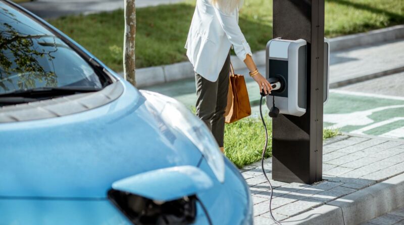 mobilité électrique femme chargeant son véhicule